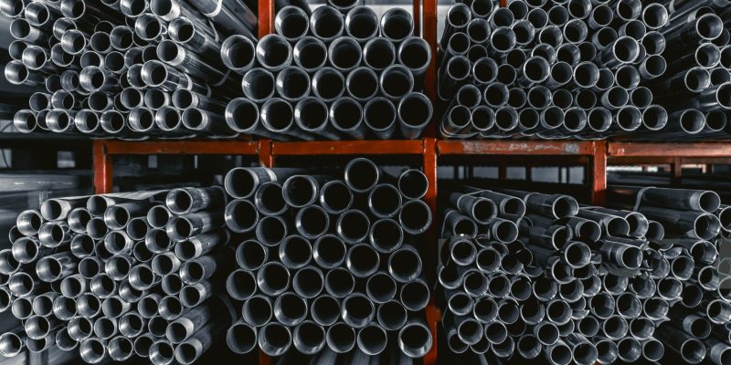 Metal pipes connector tubes. Construction cylindrical steel pipe stacked valious size in construction equipment store shelf.